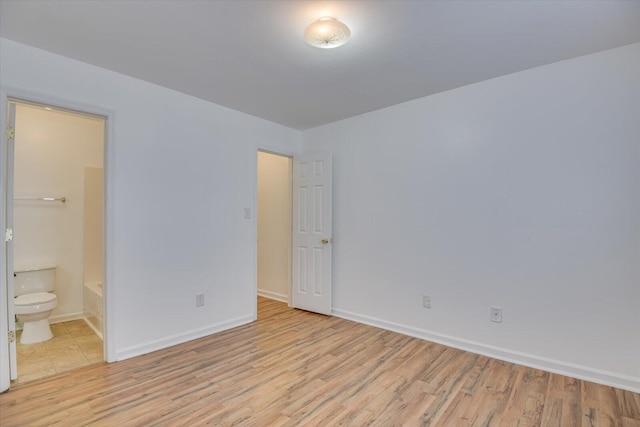 unfurnished bedroom with light wood-type flooring and ensuite bath