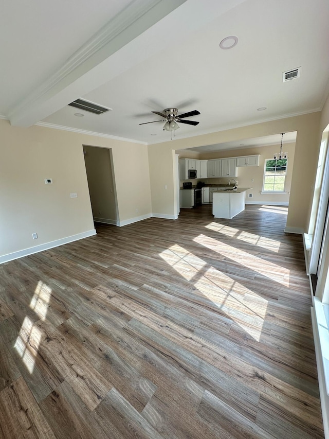 unfurnished living room with baseboards, visible vents, ornamental molding, and dark wood finished floors