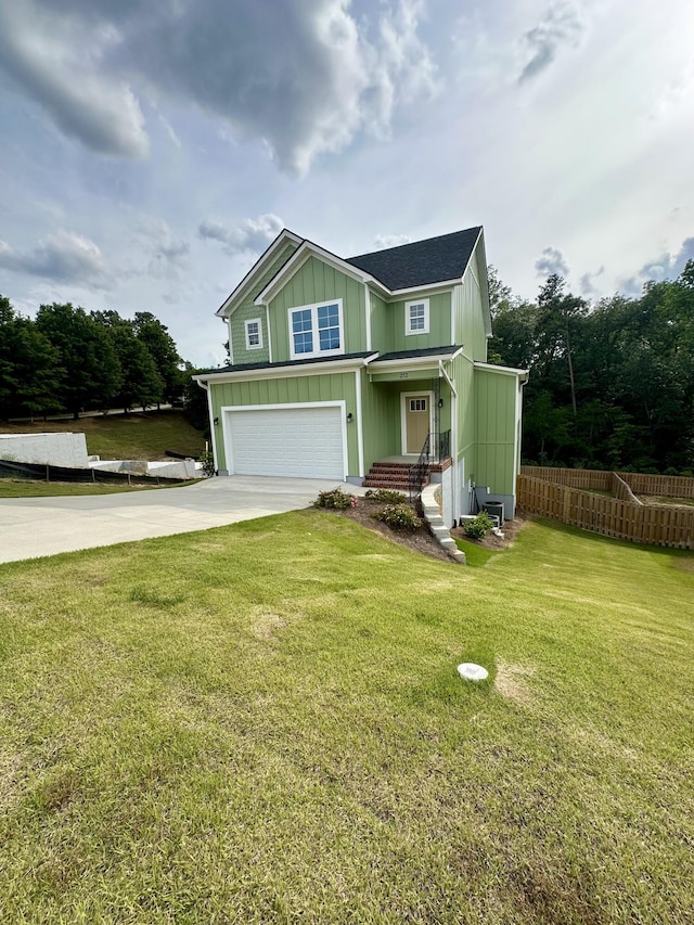 view of front facade featuring a garage, fence, a front yard, board and batten siding, and driveway