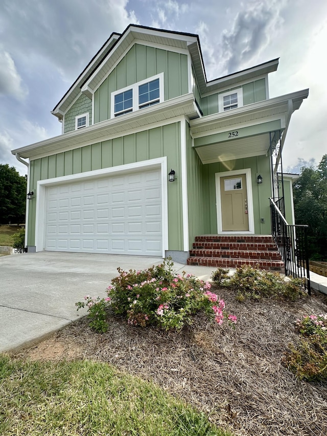 view of front of house featuring board and batten siding, an attached garage, driveway, and entry steps