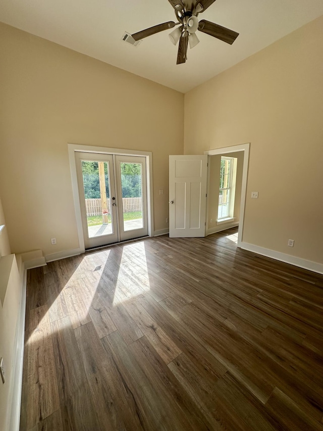 empty room featuring a healthy amount of sunlight, french doors, dark wood-style floors, and visible vents