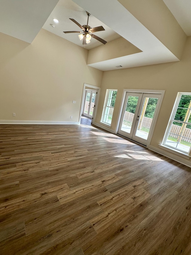 unfurnished living room with visible vents, dark wood-style flooring, baseboards, french doors, and a ceiling fan