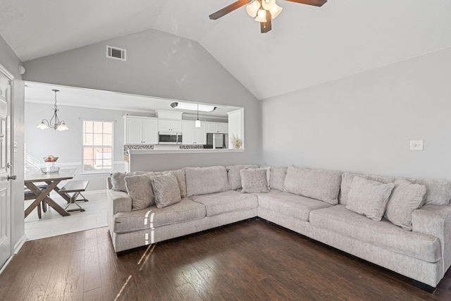 living room featuring dark wood-type flooring, high vaulted ceiling, and ceiling fan with notable chandelier