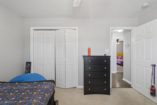 carpeted bedroom featuring ceiling fan and a closet