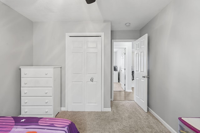 bedroom with ceiling fan, light carpet, and a closet