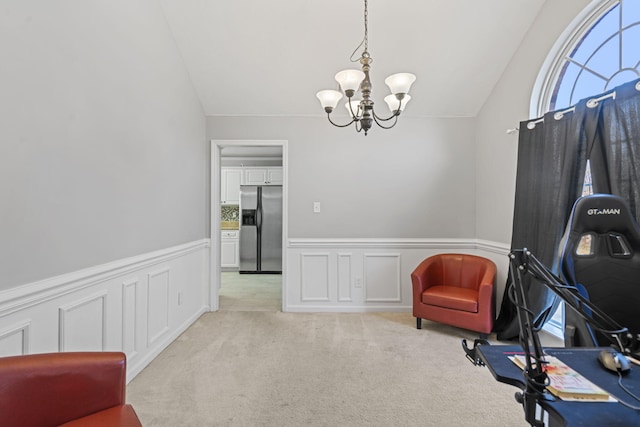 sitting room with lofted ceiling, light carpet, and a notable chandelier