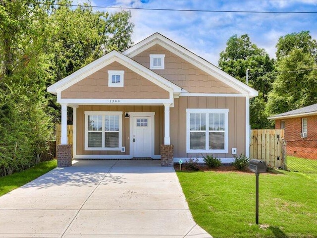 craftsman-style home featuring covered porch and a front lawn