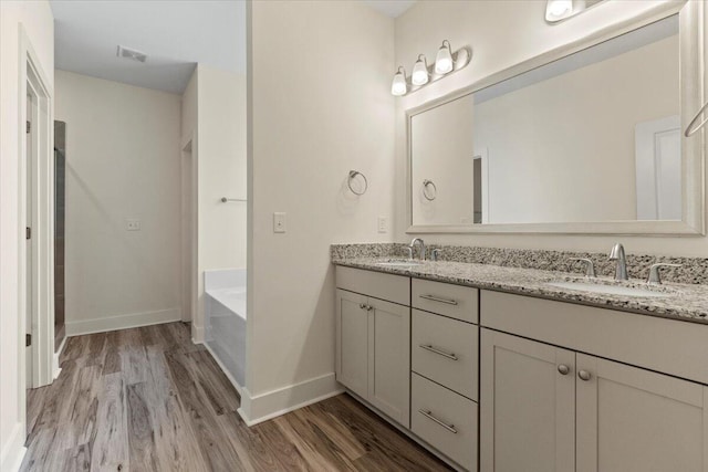 1404 Feldspar Ct, Augusta, GA 30909 - bathroom featuring wood finished floors, double vanity, and a bath