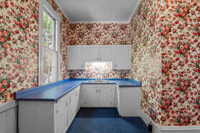 223 E Robert Toombs Ave, Washington, GA 30673 - kitchen featuring wallpapered walls, a sink, ornamental molding, white cabinetry, and dark colored carpet