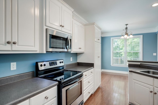 1102 Highmoor Ln, Evans, GA 30809 - kitchen with appliances with stainless steel finishes, dark countertops, white cabinetry, and crown molding