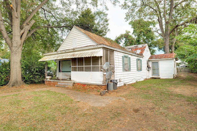 view of front of home with a sunroom and a front yard