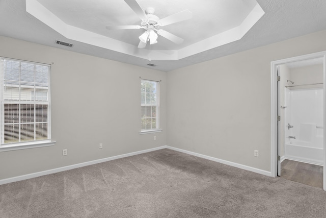 159 Redbud Dr, North Augusta, SC 29841 - unfurnished bedroom with a tray ceiling, carpet flooring, connected bathroom, and ceiling fan