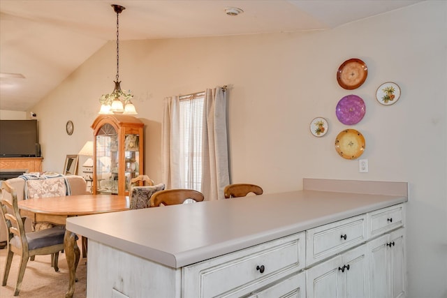 8030 Reagan Cir, Augusta, GA 30909 - kitchen with lofted ceiling, light carpet, light countertops, hanging light fixtures, and a peninsula