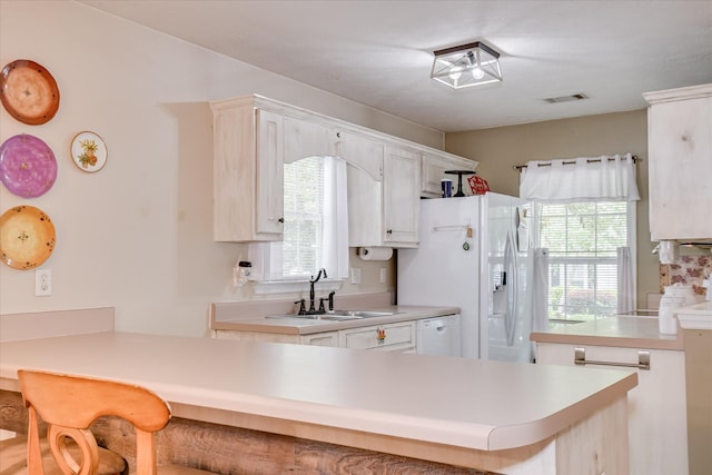 8030 Reagan Cir, Augusta, GA 30909 - kitchen featuring a peninsula, a kitchen breakfast bar, healthy amount of natural light, and white appliances
