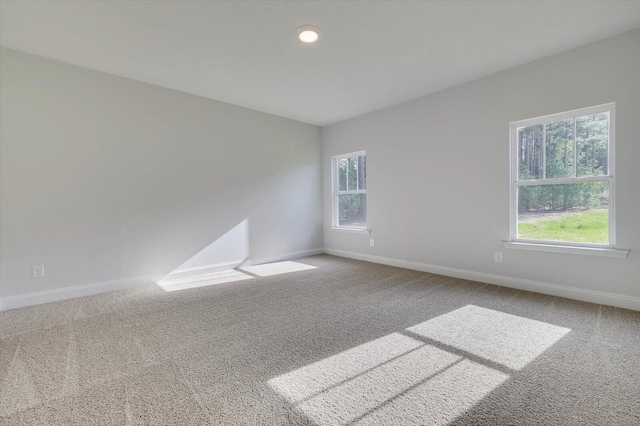 carpeted empty room featuring plenty of natural light and baseboards