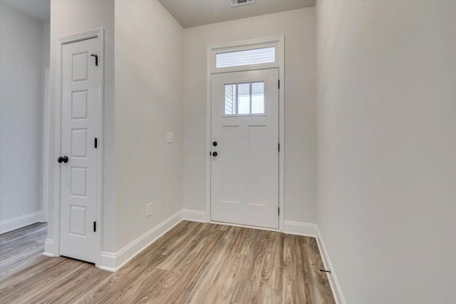 entryway with baseboards, visible vents, and light wood finished floors