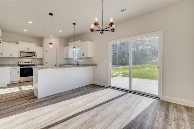 kitchen with baseboards, white cabinets, light wood-style flooring, stainless steel appliances, and recessed lighting