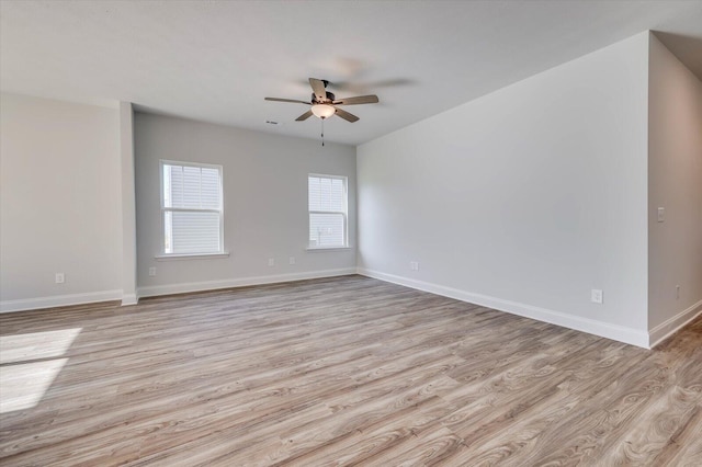 empty room featuring light wood-style floors, baseboards, and a ceiling fan