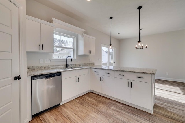 kitchen featuring light wood-type flooring, dishwasher, a peninsula, and a sink