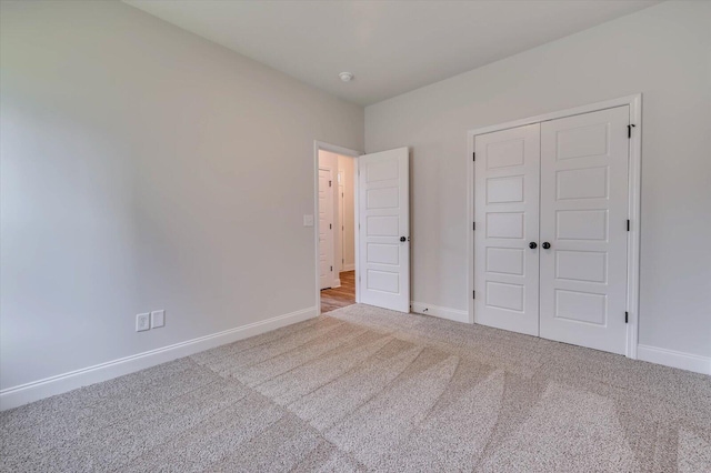 unfurnished bedroom featuring a closet, carpet flooring, and baseboards