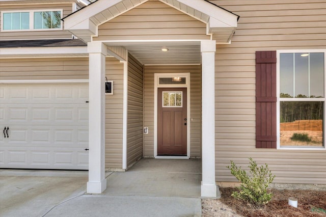 doorway to property featuring a garage and concrete driveway