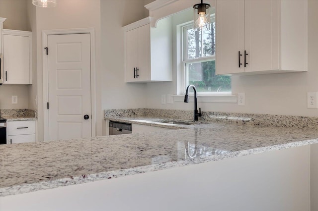 kitchen featuring a sink, white cabinetry, and decorative light fixtures