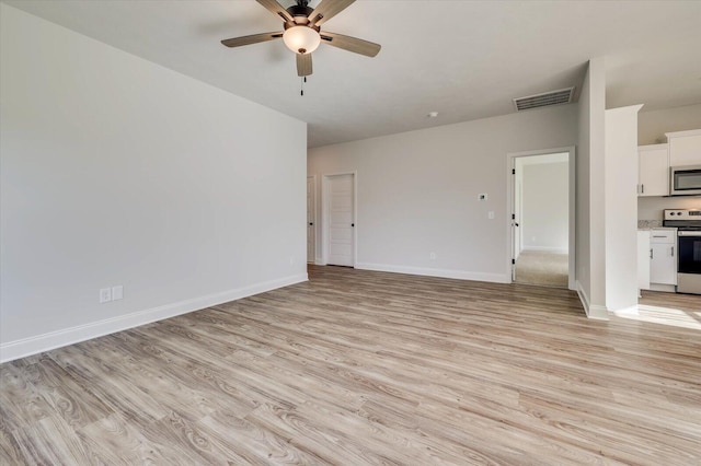 unfurnished living room with light wood-type flooring, visible vents, and baseboards