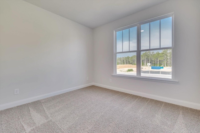 spare room featuring carpet floors and baseboards