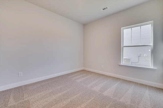 empty room with light colored carpet, visible vents, and baseboards