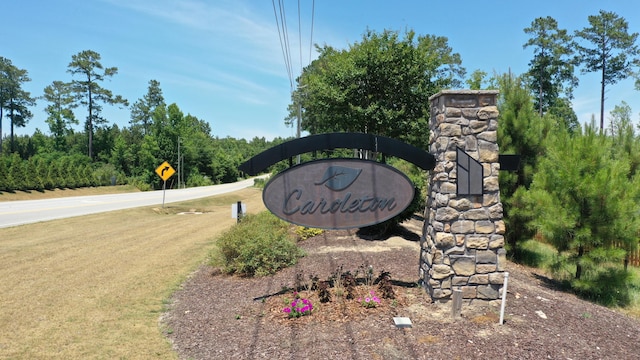 community / neighborhood sign featuring a yard