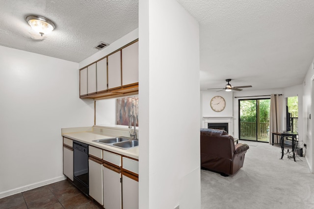 kitchen featuring ceiling fan, dishwasher, sink, a textured ceiling, and white cabinets