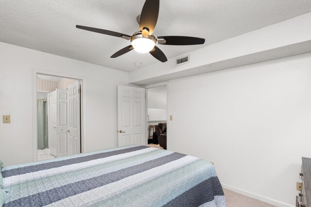 bedroom featuring ceiling fan, light colored carpet, and a textured ceiling