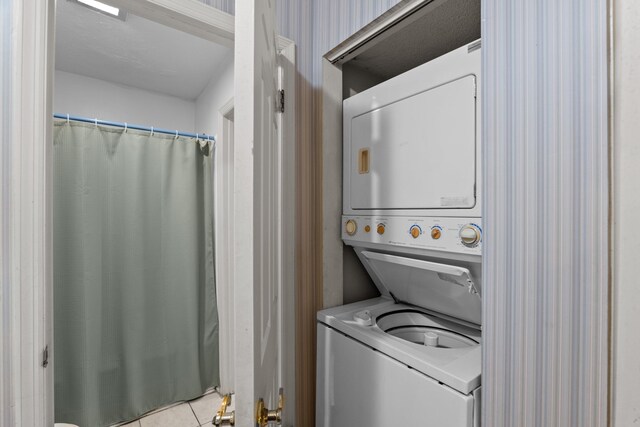 washroom with light tile patterned floors and stacked washer and clothes dryer