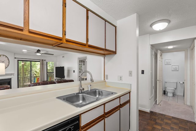 kitchen featuring a textured ceiling, dark parquet floors, ceiling fan, sink, and white cabinets