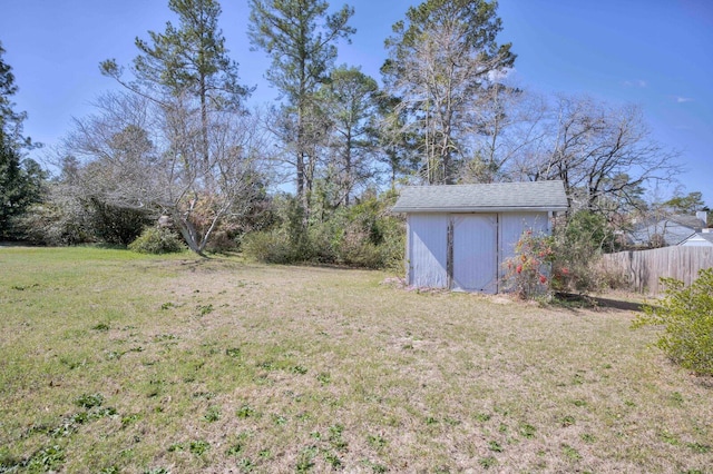 view of yard featuring an outbuilding, fence, and a storage shed