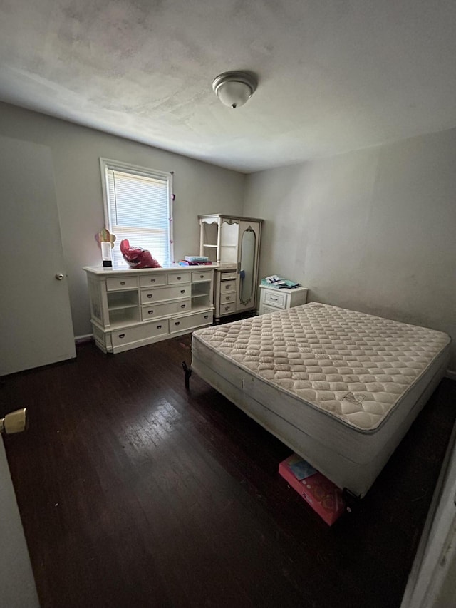 bedroom with dark wood-style floors and baseboards