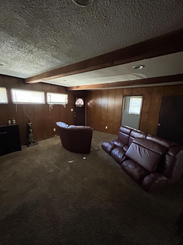 home theater with beam ceiling, carpet flooring, wooden walls, and a textured ceiling