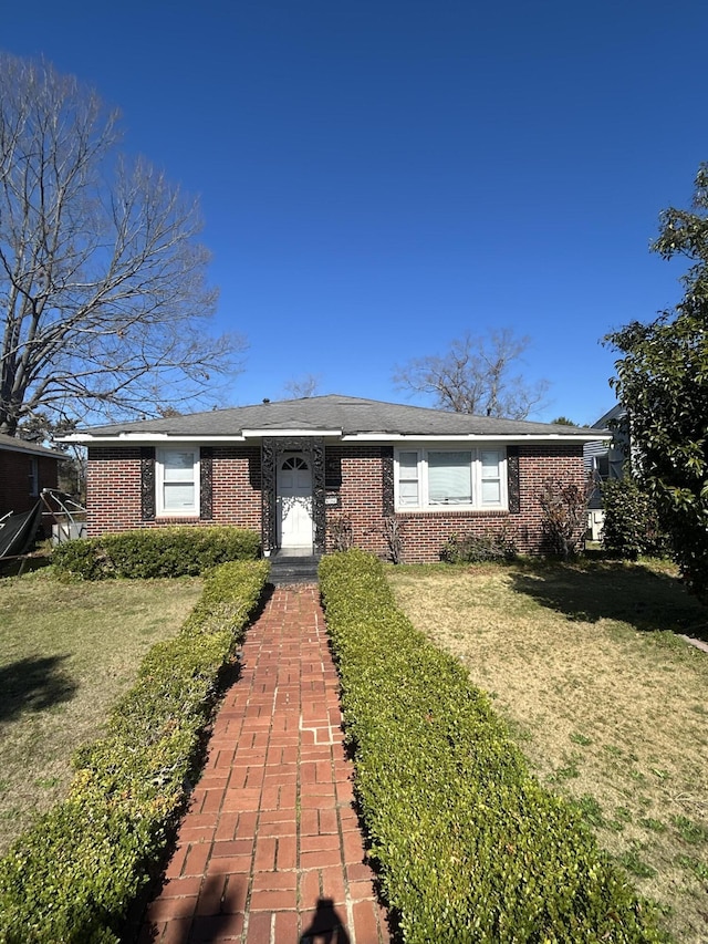 ranch-style house with a front lawn and brick siding