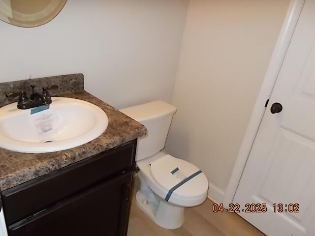 half bath featuring toilet and vanity