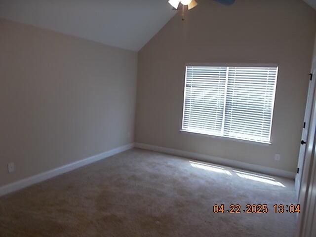 carpeted empty room with ceiling fan, baseboards, and lofted ceiling