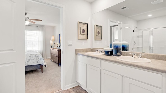 bathroom featuring ceiling fan, vanity, and a shower with door