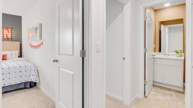 carpeted bedroom with sink and connected bathroom