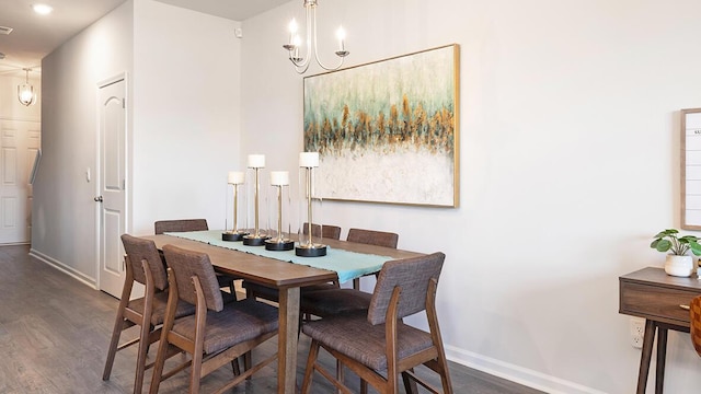 dining space featuring dark wood-type flooring and a chandelier