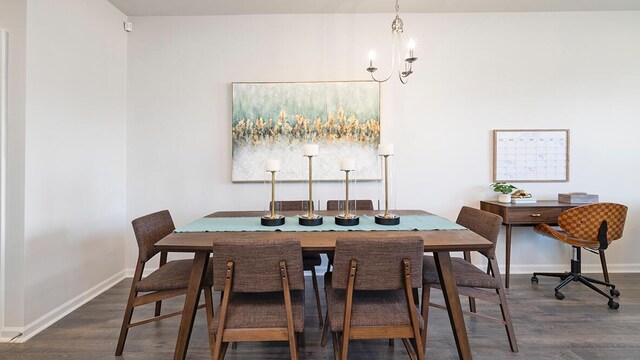 dining space featuring dark wood-type flooring and a notable chandelier