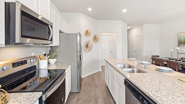 kitchen featuring white cabinetry, sink, stainless steel appliances, and light stone countertops