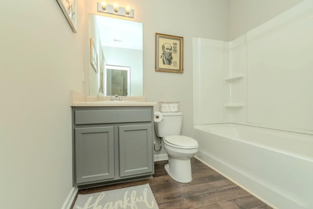 bathroom with wood finished floors, toilet, vanity, and baseboards