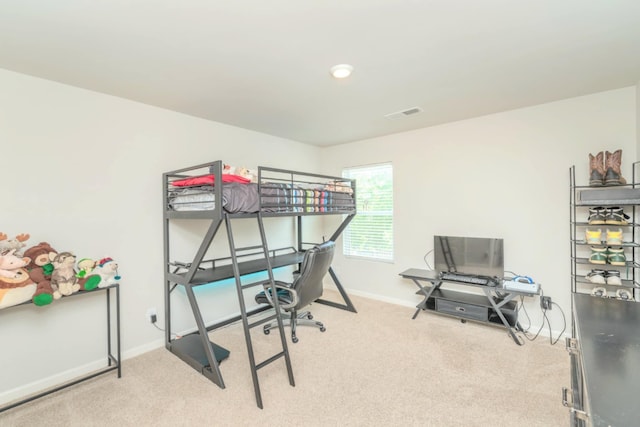 carpeted bedroom featuring baseboards and a desk