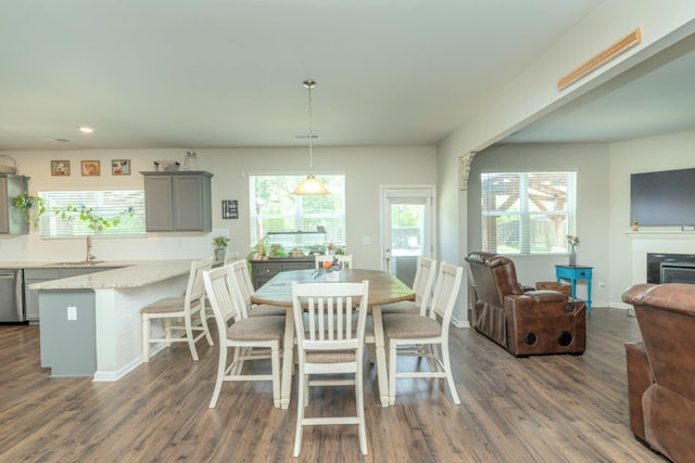 dining space with dark wood-style flooring, recessed lighting, a fireplace, and baseboards