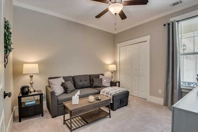 living room featuring light carpet, ceiling fan, a healthy amount of sunlight, and ornamental molding