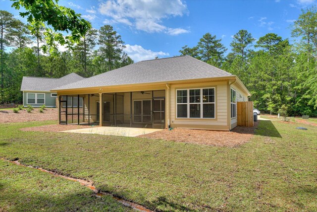 rear view of property with a sunroom, a yard, and a patio